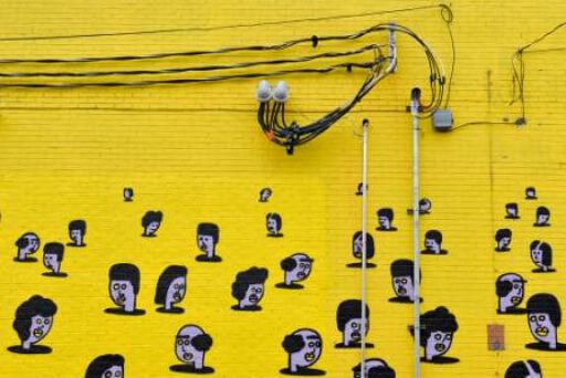 heads floating on a yellow wall